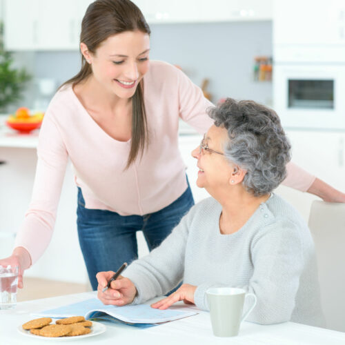 Carer helping woman at home Carer helping woman at home